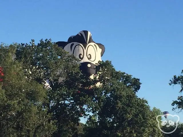 Hot air balloon peeking behind the trees. 