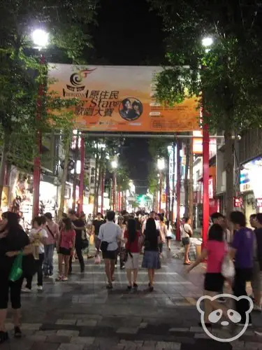 People walking along Ximending Pedestrian Street at night.