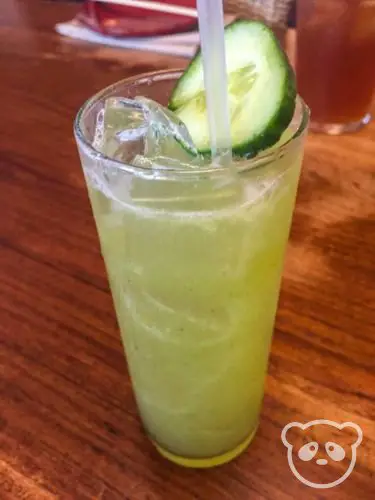 A glass of cucumber limeade with a cucumber slice on the top.